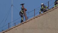 Los bomberos colocan la chimenea del Vaticano que anunciará la elección de un nuevo Papa 